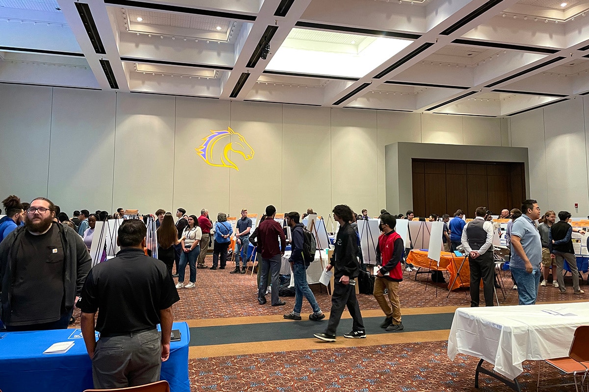 People walking around and looking at various projects at a UTA event - opens in a new tab