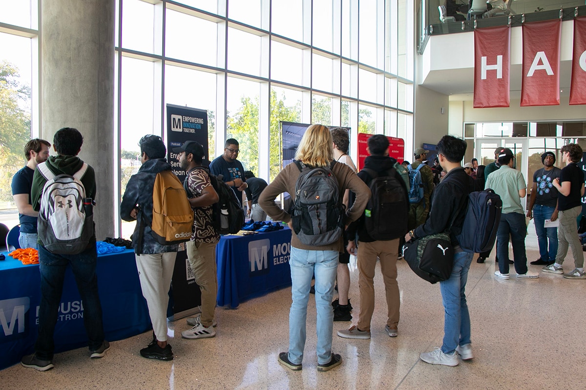 Students with backpacks gathered around Mouser Electronics tables in a large, well-lit indoor space with banners - opens in a new tab