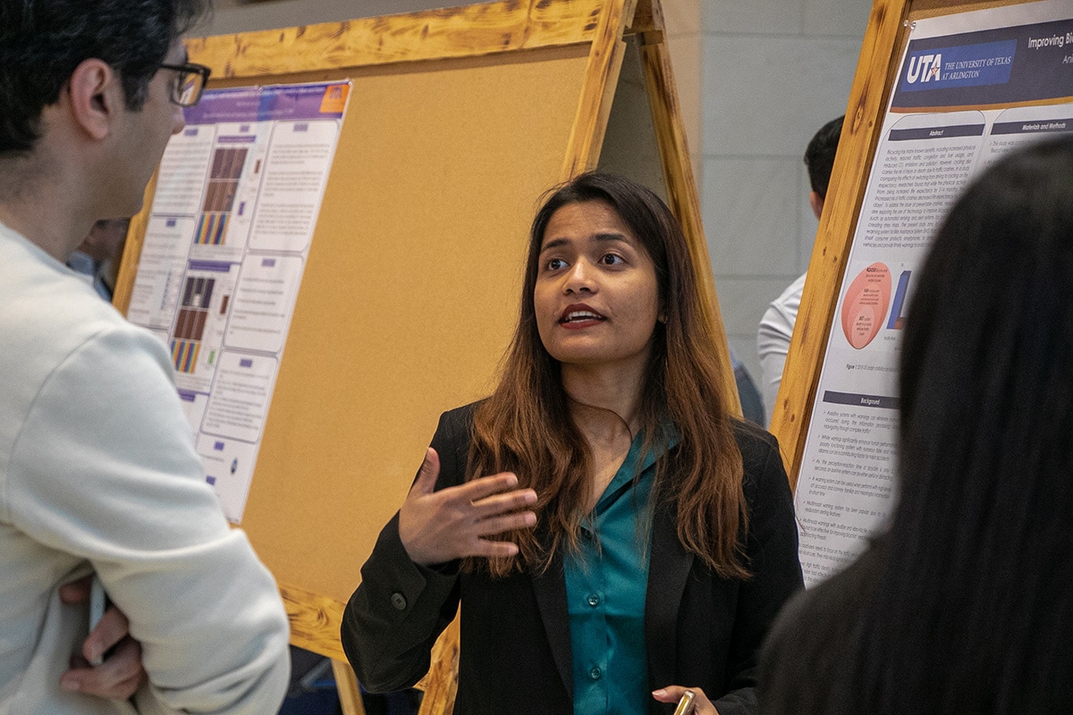 Woman explaining her project to two other people at a UTA event - opens in a new tab