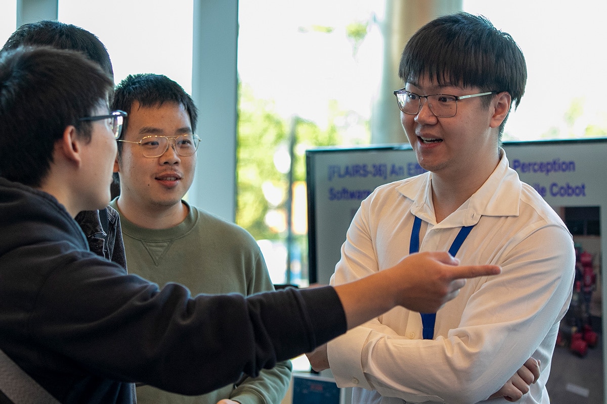 Four people engaged in a discussion - opens in a new tab