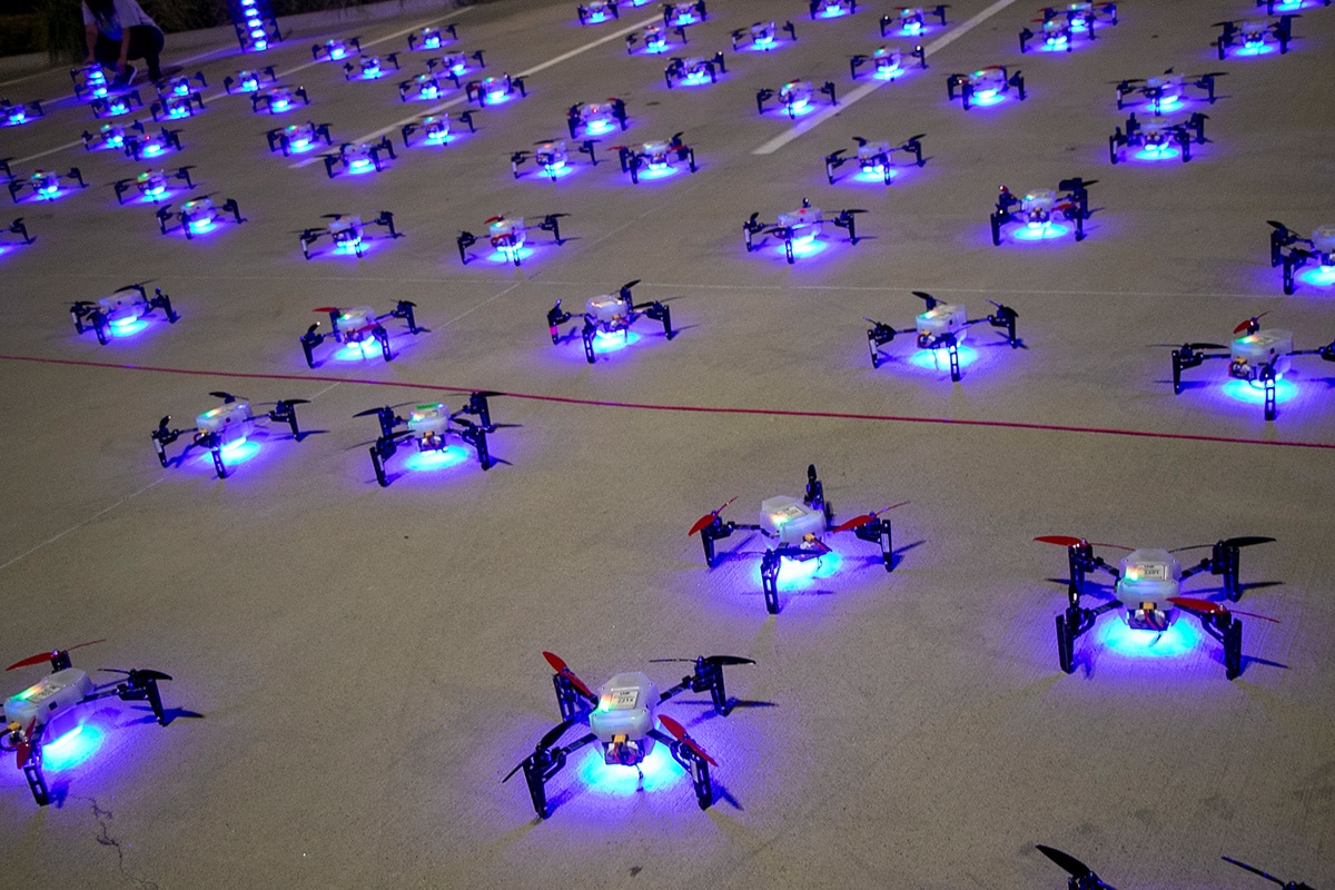 Hundreds of drones on the ground with LED lights on, preparing for light show - opens in a new tab